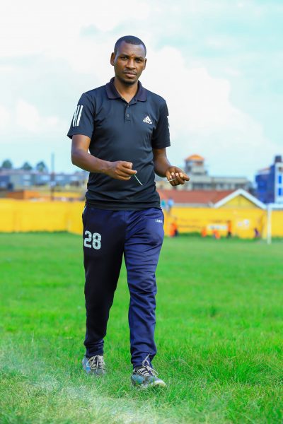 Head Coach Tushabe Denis walking around the pitch prior to kick off.